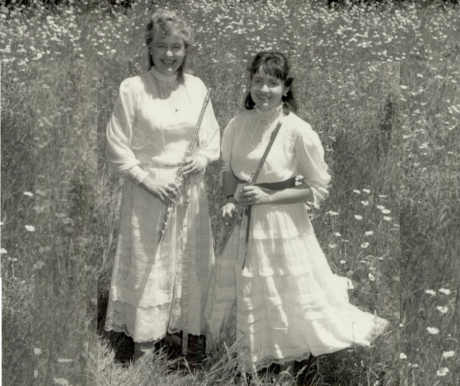 The New England Flute Duo poses with flutes in a meadow